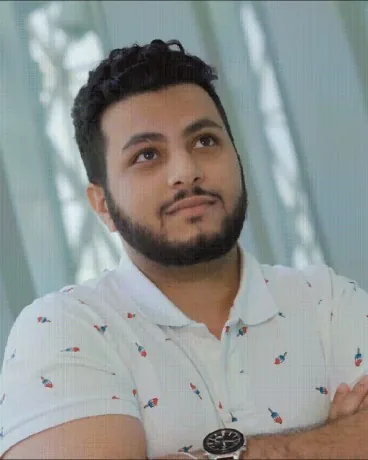 Ahmad Al Surmi, arms crossed, looking up and to the side